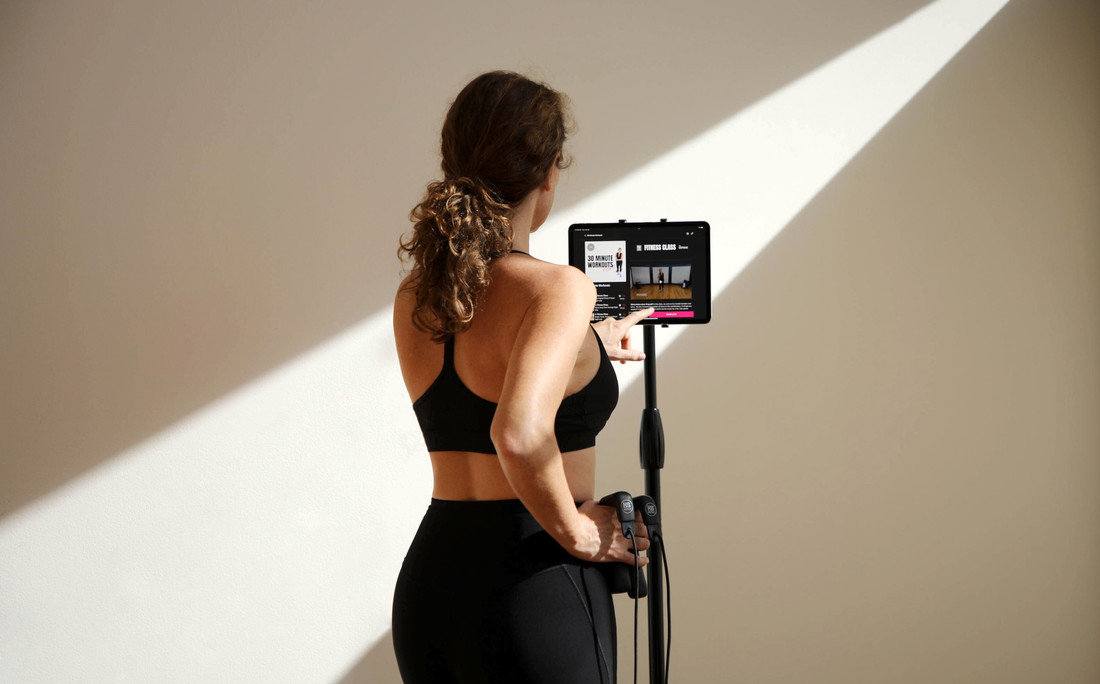 erson doing a HupSix low-impact cardio workout at home, following the class on TV.